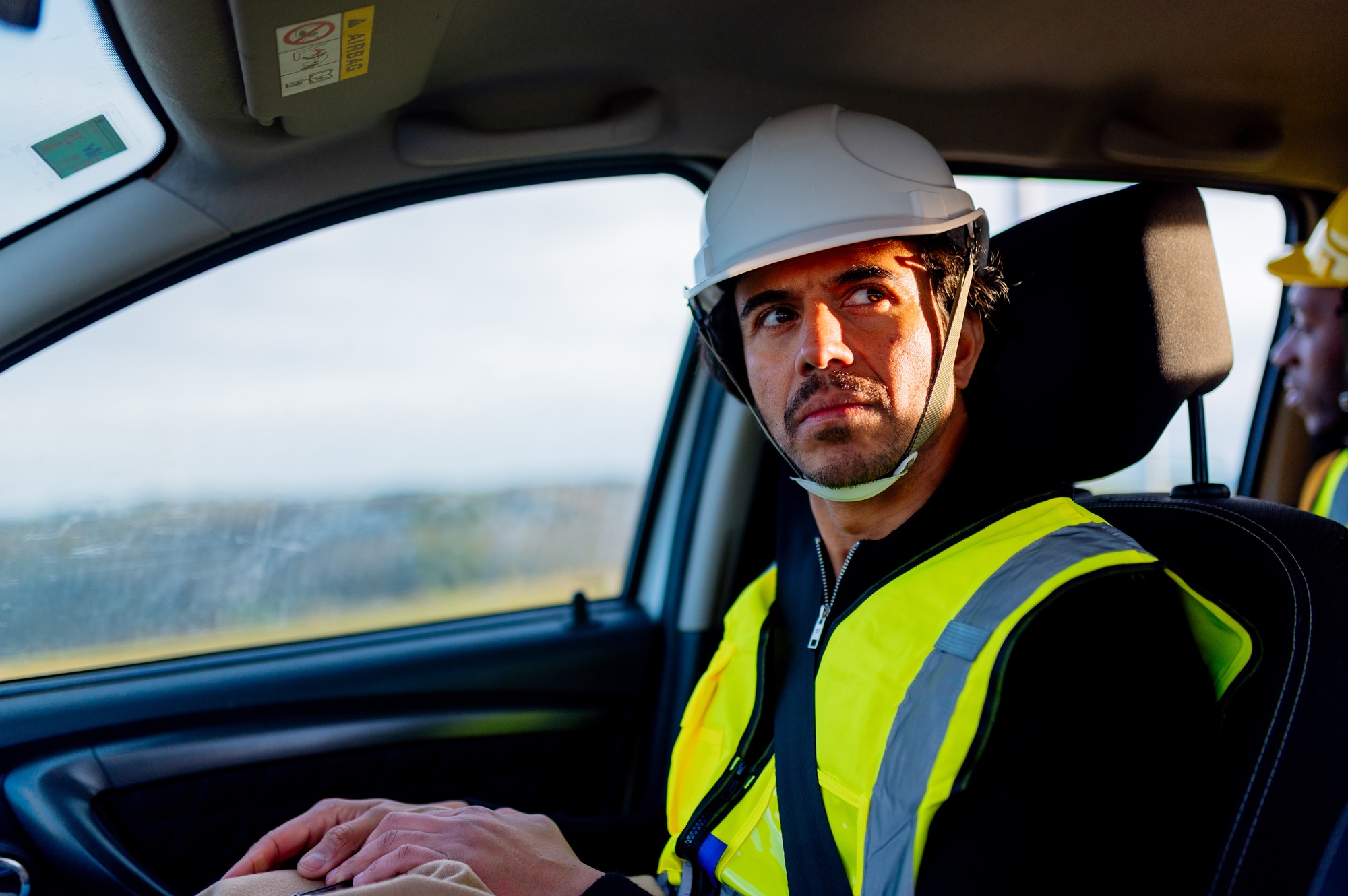 Power station worker arriving at work by car with colleague